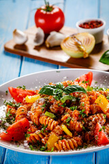 Fusilli with tomato sauce, meat and parmesan on wooden table 