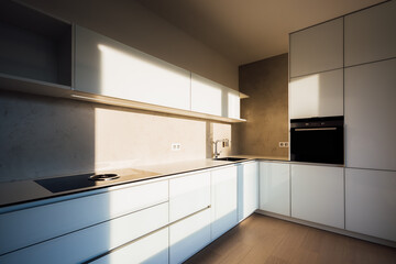 Fototapeta na wymiar New modern white kitchen in minimalist design, during morning sunrise hour, with modern appliances, wall-sockets and premium materials such as glass, concrete, stainless steel and wooden floor.