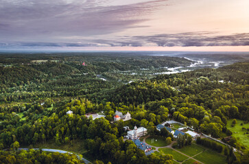 Picturesque valley of Sigulda city in sunrise colors. Panoramic view over pine forest surrounding river Gauja.