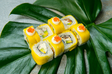 Japanese sushi roll with mango, avocado, unagi eel and Philadelphia cheese served on green tropical...