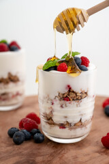 ealthy yoghurt with fruits and dripping honey. Bright and with copy space