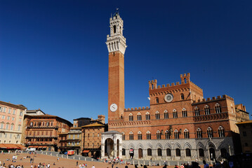 Fototapeta premium Red brick of the Palazzo Pubblico in Siena against a clear blue sky