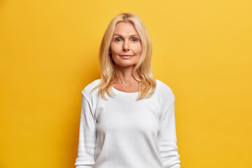 Portrait of good looking middle aged woman with wrinkled face natural beauty blonde hair looks...