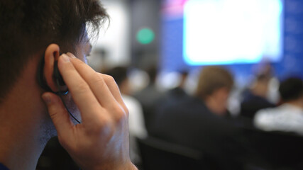 Audience business meet crowded forum person. Viewer conference listen headphone speaker auditorium....