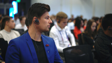 Audience business meet crowded forum person. Viewer conference listen headphone speaker auditorium. Event economic summit business man spectator. Group people listening translate speech crowd audience