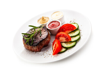 Barbecue beef steak with fresh tomatoes and cucumbers, mustard, mayonnaise and ketchup on white background
