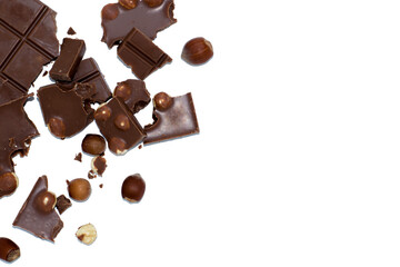 Pieces of black and milk chocolate with whole hazelnuts, on a white background, close up
