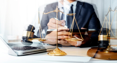 Business and lawyers discussing contract papers with brass scale on desk in office. Law, legal services, advice, justice and law concept
