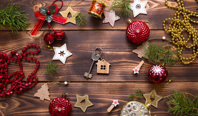 Christmas flat lay on a wooden background with keys to a new house in the center with a place for notes. New year, transfer, shares of the mortgage, the rental of a cottage. Space for text, to do list