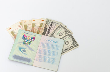 Pasaporte cubano y dinero sobre fondo blanco. Dólares y dinero cubano.