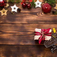 Christmas flat lay on the theme of shopping, buying gifts for the new year. Black Friday, sale, decor of stars, spruce branches, ball, beads, garlands, cones on a wooden background. Space for text