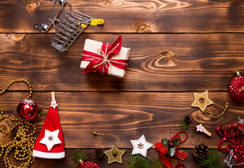 Christmas flat lay on the theme of shopping, buying gifts for the new year. Black Friday, sale, decor of stars, spruce branches, ball, beads, garlands, cones on a wooden background. Space for text
