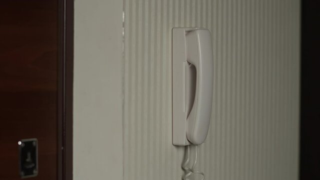 man picks up the intercom and opens the door