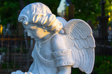 Figure of a praying angel. A very ancient stone statue. Death. Sad angel as symbol of pain, fear...