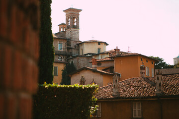 Close up. The street view of the old Italian colorful buildings with wooden shutters, tiled roofs, towers, shops in the city center of Bergamo, Lombardy, Italy. Vintage European architecture.