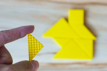 a tangram puzzle is waiting to complete the shape of a house to build a dream home, a happy life, a...