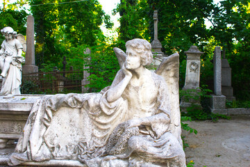 Figure of a praying angel. A very ancient stone statue. Death. Sad angel as symbol of pain, fear...