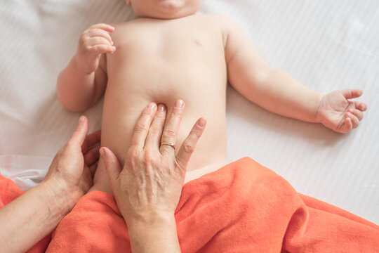 Massage stomach for little child infant makes a doctor massage therapist in a massage room with oil on bed. massage with colic tummy. manual therapy for childrens heals. motherhood.