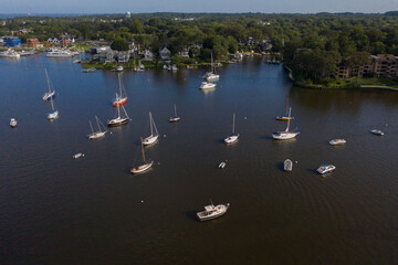Aerial view of colorful sailboat moorings and docks surrounded by colorful residential rooftops on and azure blue Spa Creek, in historic downtown Annapolis Maryland on a sunny summer day