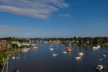 Fototapeta na wymiar Aerial view of colorful sailboat moorings and docks surrounded by colorful residential rooftops on and azure blue Spa Creek, in historic downtown Annapolis Maryland on a sunny summer day
