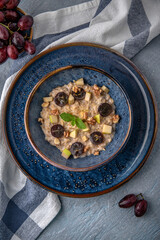 Breakfast of oatmeal with fruit. Natural delicious food. Greek cuisine menu. Still life in a marine style on a blue background.