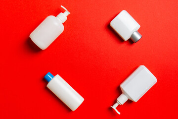 Set of White Cosmetic containers isolated on colored background, top view with copy space. Group of plastic bodycare bottle containers with empty space for you design