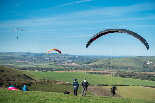 Paragliders take off from the South Downs in Sussex