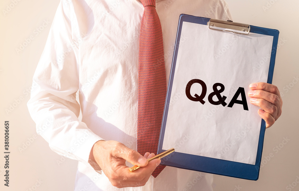 Poster questions and answers concept. q and a text on on white paper board in male hands