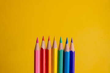 seven colored pencils in the center in row order and in gradient color, with colors like pink,...