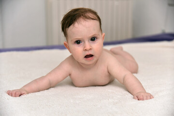 Happy Three Month Old Baby girl  on White Background. Baby girl lying on her stomach on a white background.