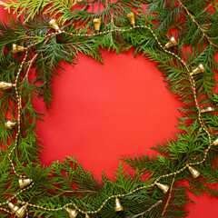 Fototapeta na wymiar Christmas frame. Fir tree branch on red background. Top view with copy space