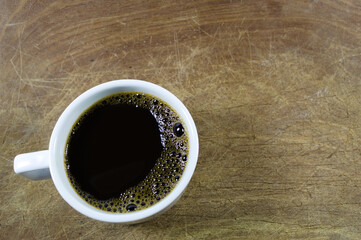 White cup of coffee on wooden background
