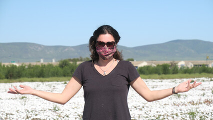 Close up of female with face mask standing amongst white flowers