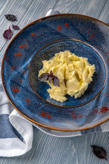 Mashed potatoes with olive oil. Natural delicious food. Greek cuisine menu. Still life in a marine style on a blue background.