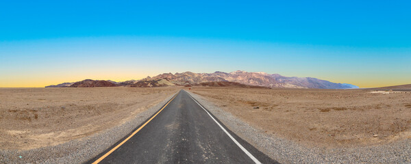 road in the death valley national park with mountains and blue sky