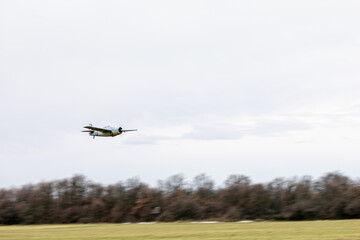 model airplane over fields on a cloudy day