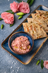 Cheese cream snack with smoked salmon with pita bread. Natural delicious food. Greek cuisine menu. Still life in a marine style on a blue background.