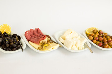 Olive varieties,cheese and salami breakfast plates designed on white surface with large copy space