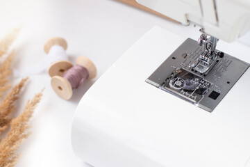 sewing machine and two spools of thread close up on a white background. Set 3\4