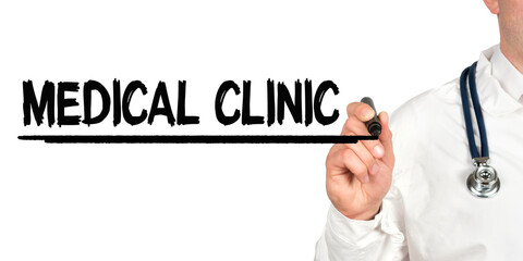 Doctor writes the word - MEDICAL CLINIC. Image of a hand holding a marker isolated on a white background.