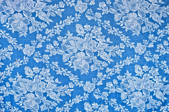 White Floral Pattern On A Blue Cloth.