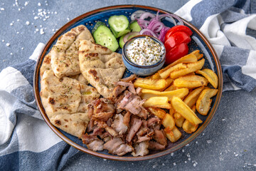 Pita shawarma with olive oil, meat, potatoes and vegetables. Natural delicious food. Greek cuisine menu. Still life in a marine style on a blue background.
