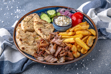 Pita shawarma with olive oil, meat, potatoes and vegetables. Natural delicious food. Greek cuisine menu. Still life in a marine style on a blue background.