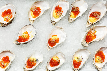 Fresh Oysters close-up on blue plate, served table with oysters, lemon and ice. Healthy sea food. Oyster dinner with champagne in restaurant. Gourmet food.