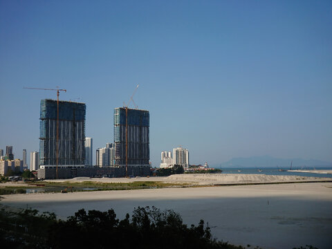 Viewing out from a hotel apartment window of the reclaimed land and surrounding building constructions near the beach coastline of Penang Georgetown