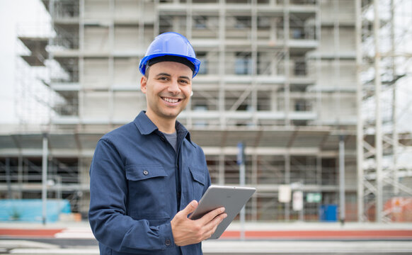 Site Manager Using His Tablet In Front Of A Construction Site