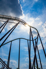 Roller coaster against a cloudy sunset sky