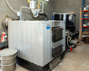 Hot water solid fuel boiler with tubes and tachometer installed in the boiler room