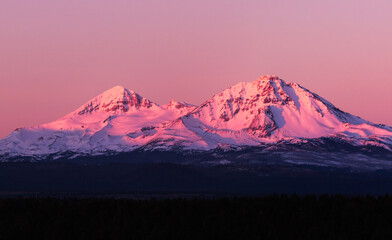 Sunrise over the North and Middle Sister mountains in central Oregon near Bend.