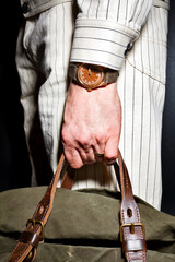 close up of male hand with luxury chronometer holding bag 